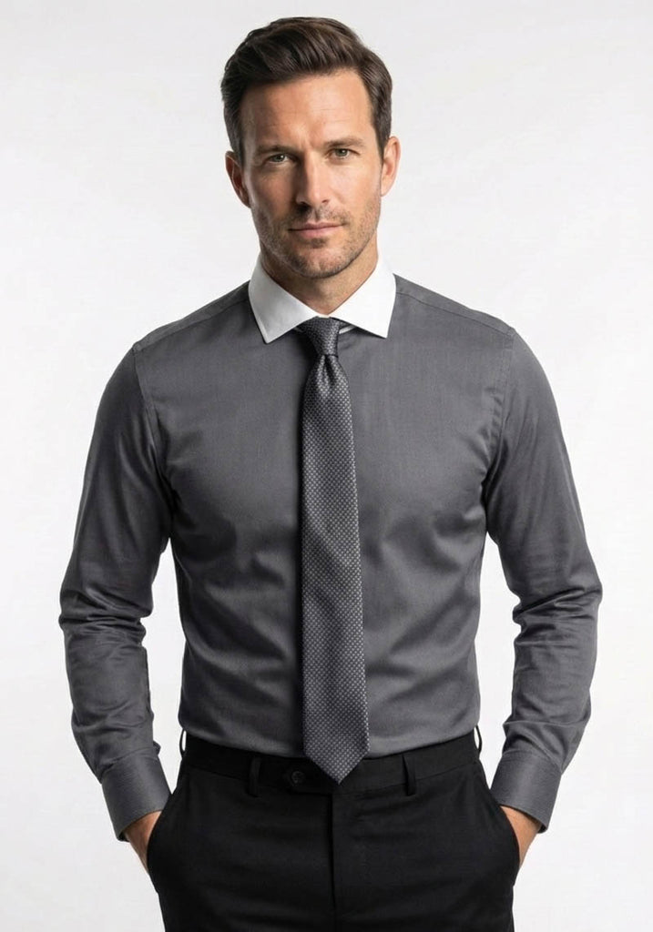 Man wearing a gray dress shirt with a patterned tie on a white background